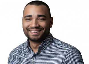 Man smiling, wearing a checkered shirt